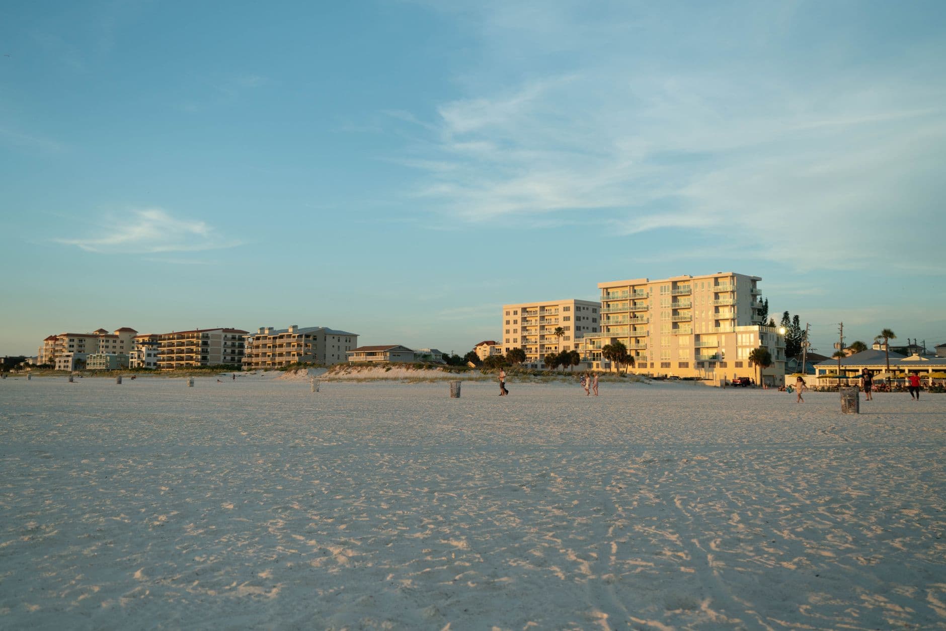 Serene beach scene during sunset with beachfront condos in the background.