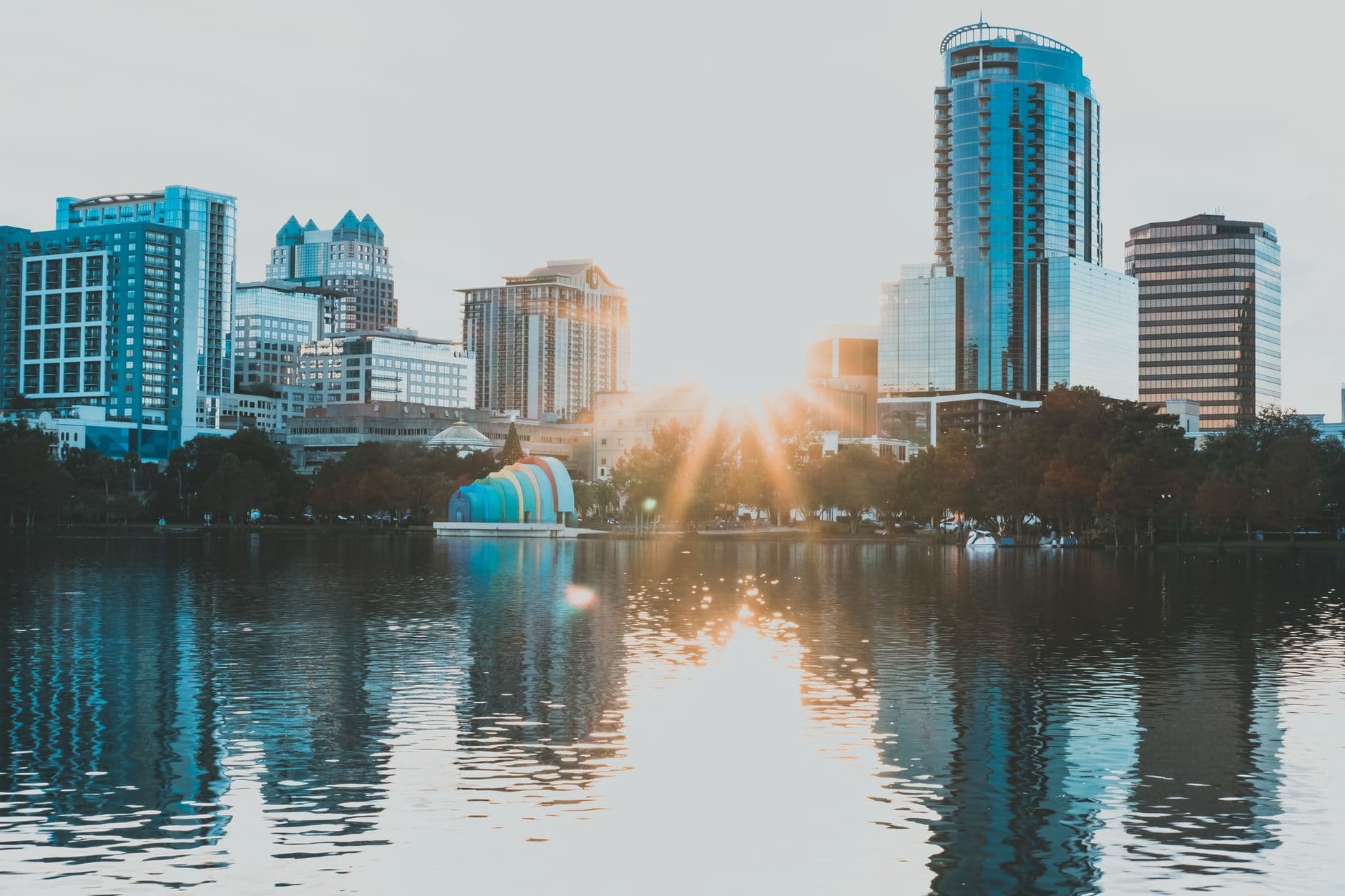 Capture of Orlando's skyline reflecting in a lake during sunrise, showcasing urban beauty and tranquility.